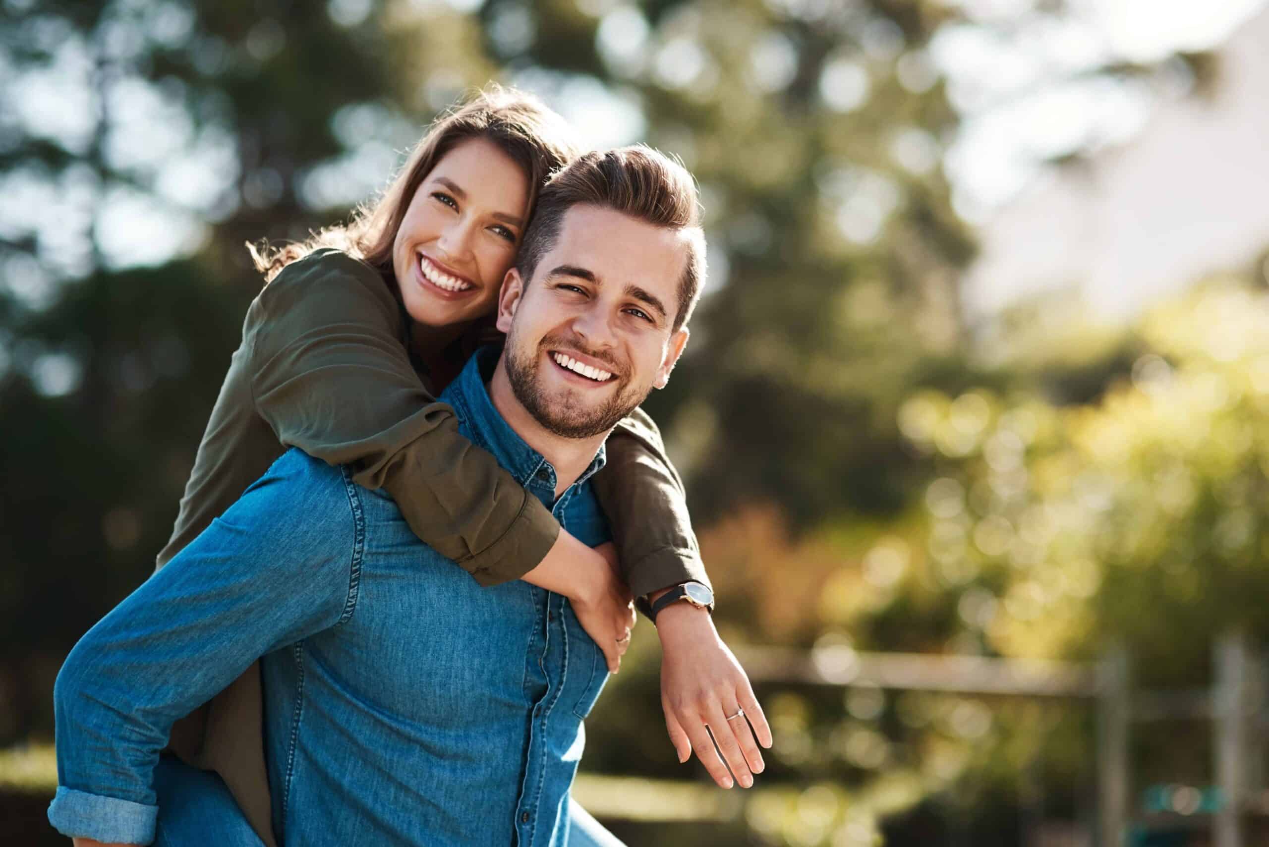 Smile, portrait couple and piggyback outdoor for summer holiday, marriage support or anniversary date. Happy, man and woman playful embrace of vacation travel, love together and bonding in nature